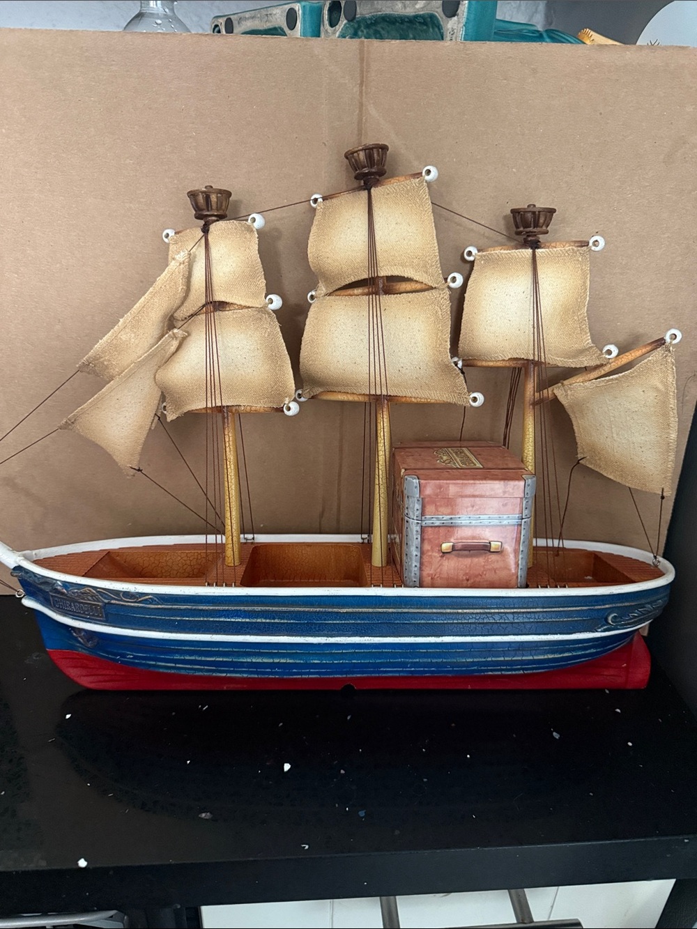 Decorative Blue and Red Wooden Sailboat with Beige Sails